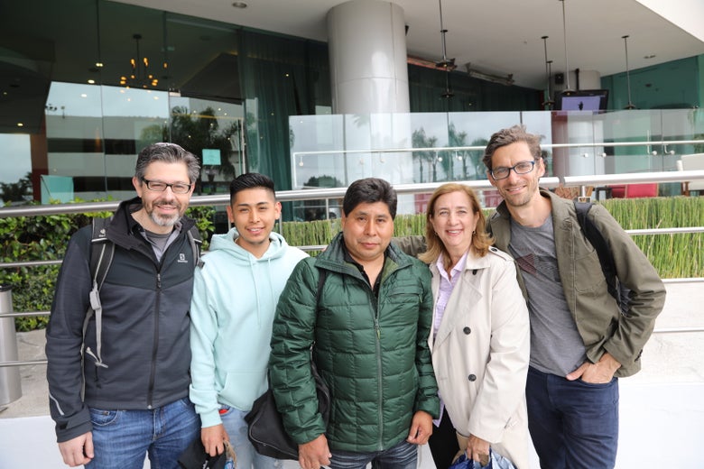 A group of people posing in front of a building entrance.